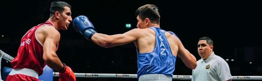 Казахстанский боксер в синей форме наносит удар сопернику — 1xBet