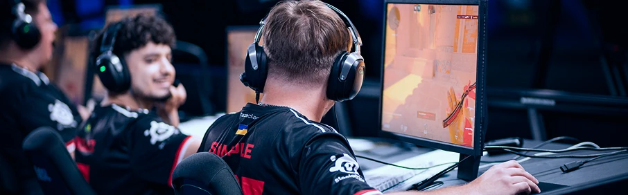 Игрок за компьютером на киберспортивном турнире в наушниках — 1xbet